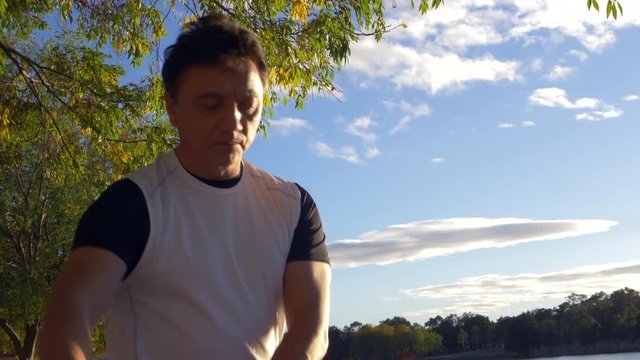 A man is meditation with Tai-chi as he gets ready for the day. A view of him from waist up with early morning setting.