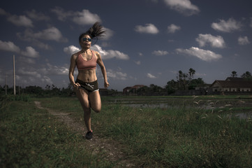 athletic runner Asian woman training running series workout working hard outdoors on field...