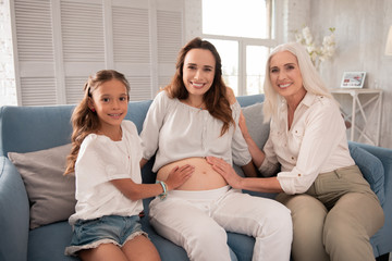 Family time. Blonde-haired smiling grandmother coming to her family house while spending unforgettable weekend together