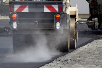Baustelle: Straßenwalze walzt Asphalt
