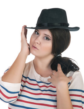 buxomy serious girl with a hat on a white background.