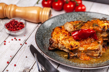 Mexican cuisine, pork or beef steak with a spicy sauce of salsa. with red pepper, marasm and titanium, cherry tomatoes, knife and fork.