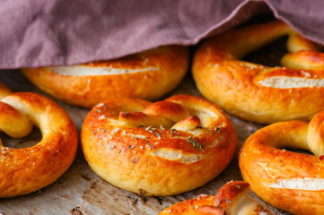 Traditional salted pretzels with oregano over wooden background. Oktoberfest or beer snack concept.