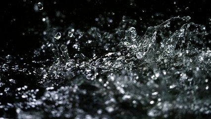 Water splash on black background color which represent clean and pure natural freshness of liquid...