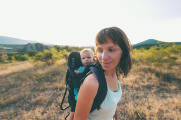  A woman is carrying a backpack with her baby.