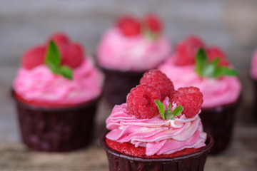 homemade cupcakes with pink cream and raspberry