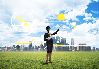 Camera headed woman standing on green grass against modern cityscape