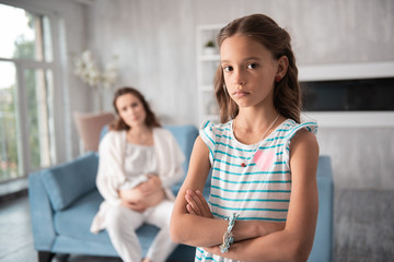 Nice pendant. Dark-eyed beautiful girl wearing nice pendant while standing in living room at home