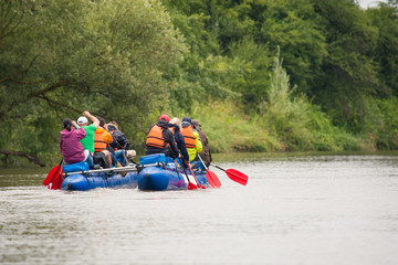 photo of people who float along the river and sprint on a catamaran