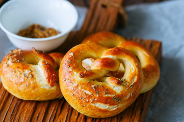 Traditional salted pretzels with oregano over wooden background. Oktoberfest or beer snack concept.