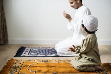 Muslim boy learning how to make Dua to Allah - obrazy, fototapety, plakaty