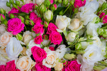 A bouquet of flowers from bright pink roses and white bush roses. Romantic gift for the girl.