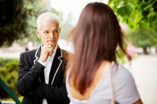 Portrait Of Old Bussines Man In Black Jacket With Woman. Look Around.