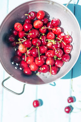 Summer red cherries on blue wooden background 