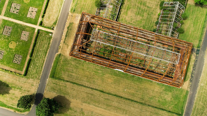 Aerial image of the metal skeleton of a large abandoned glasshouse.
