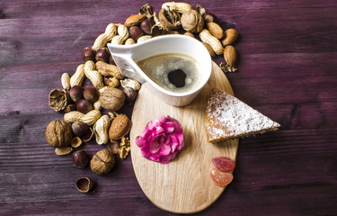 Funny portrait of girl with nuts, flower, cake and cup of coffee