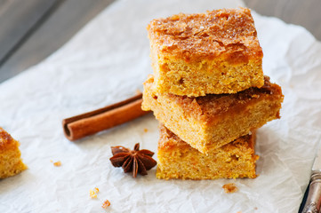 Pumpkin cornmeal bars with spices on a wooden background. Close up.