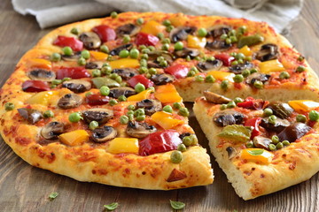 Vegetarian pizza with mushrooms, paprika and green peas