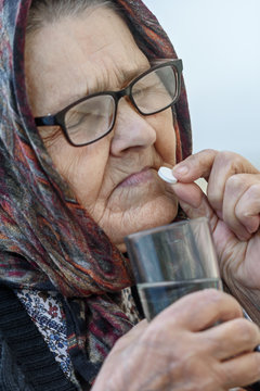  old woman takes pills, close-up