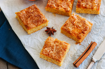 Pumpkin cornmeal bars with spices on a wooden background. Close up.