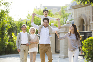 Happy Chinese family strolling outside