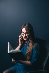 beautiful girl manager talking on the phone and reading a notebook. Office worker service operator.