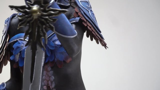 Shooting close-up of a drow woman in armor with a sword in hands, close up