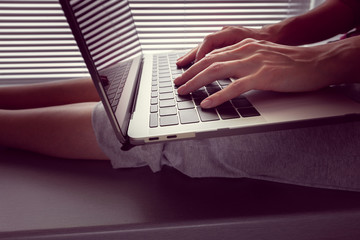 girl holds a MacBook Pro Retina on her lap and something prints. For editorial