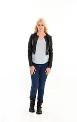 full length portrait of blonde girl wearing casual blue shirt and leather jacket. standing pose, isolated on white studio background.