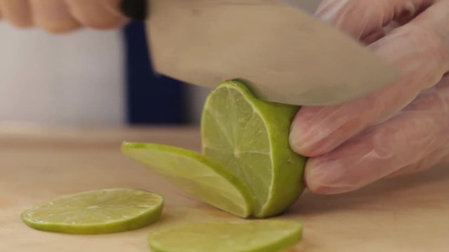 The cook cuts the lime into thin slices