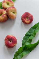 Ripe peaches with leaves on a white background, top