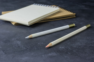 Notepads and pencils on a dark table