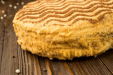 Dark chocolate vegan cake with candies and nuts on wooden background