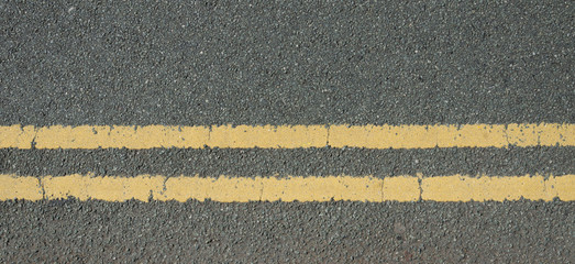 Fototapeta na wymiar A stone chipping road surface with double yellow lines