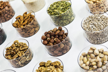 different nuts on the counter of the store. Hazelnuts, sunflower seeds, walnuts, almonds, pumpkin seeds, pistachios and others