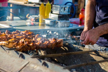 man is cooking meat. Barbecue on skewers.