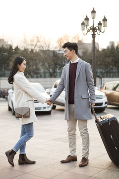 Young Chinese woman's boyfriend leaving for business travel