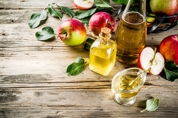 Homemade apple cider vinegar with fresh apples om wooden rustic background copy space
