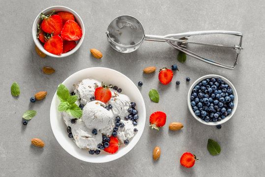 Bowl of ice cream with fruits, sundae or frozen icecream scoops with berries