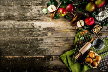 Autumn cooking background, Apple pie baking concept, fresh red apples, sweet spices, sugar, flour, rolling pin, eggs, baking utensils, wooden background copy space
