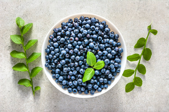 Fresh Blueberries In A Bowl, Top View On White Background. Forest Blue Berries, Healthy Food Concept.