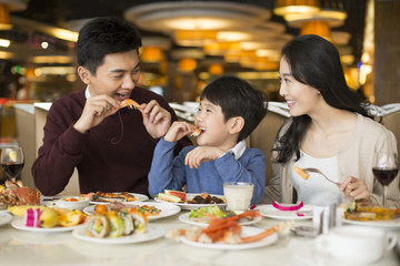 Cheerful young Chinese family having buffet dinner