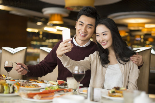 Cheerful young Chinese couple having buffet dinner
