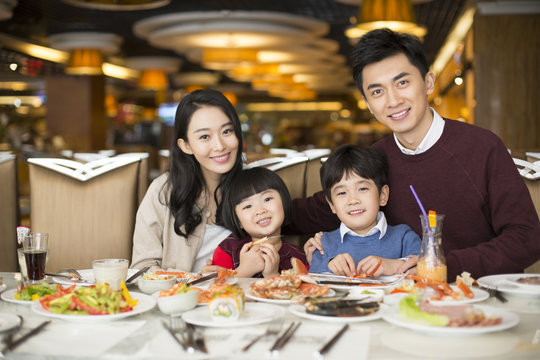 Cheerful young Chinese family having buffet dinner