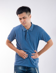 Man putting his hands for belly or stomach ache on white background