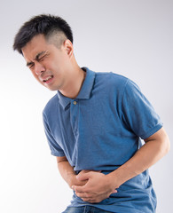 Man putting his hands for belly or stomach ache on white background