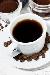 cup of freshly brewed black coffee on a white table, top view