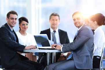 group of smiling business people sitting in a meeting room.