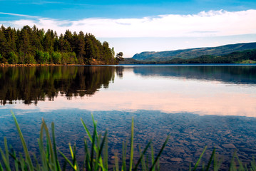 Beautiful scenic afternoon view of a quiet lake and rural mountains from Valdres, Norway