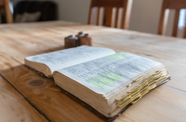 Old aged leather bound bible on a wooden table surface. Timber.